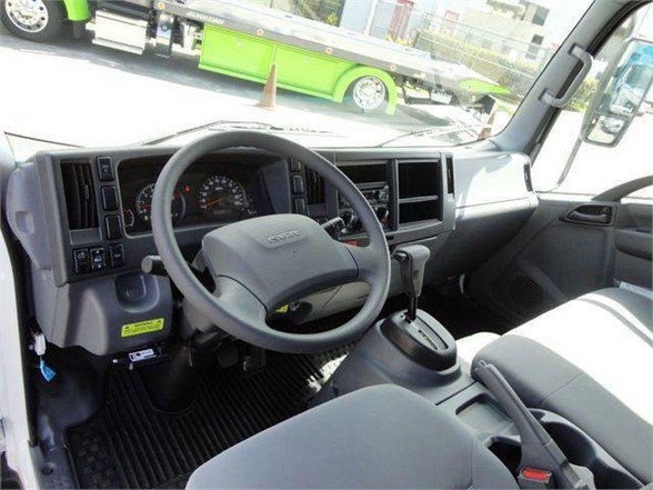 Isuzu NPR HD cab interior showing steering wheel, dashboard, and gear shifter.