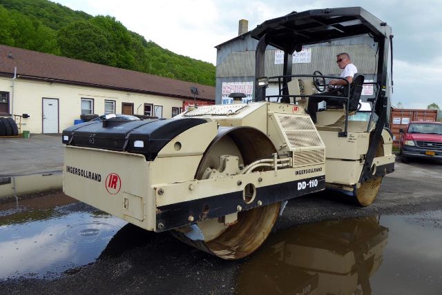 Ingersoll-Rand DD-110 pneumatic roller in service showing operator seat and controls with IR logo on front and DD-110 marking.