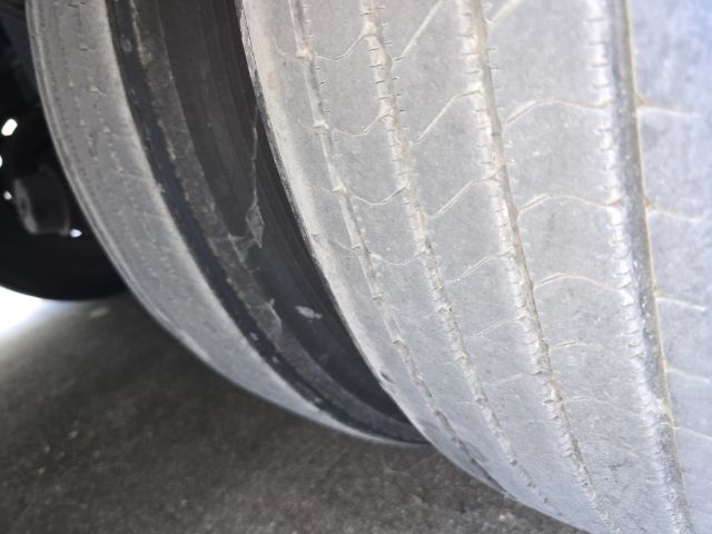 Trailer wheel with worn tread and sidewall visible.