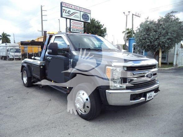 Ford F-450 pickup truck in a dealership lot with a chrome front bumper and dual rear wheel setup. Visible text includes dealership sign in background and faint watermark across the image.