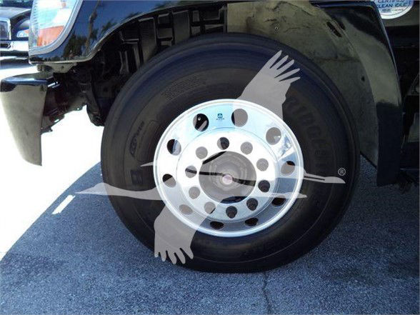 Truck wheel and fender with circular aluminum hubcap, front left wheel of a reefer truck.