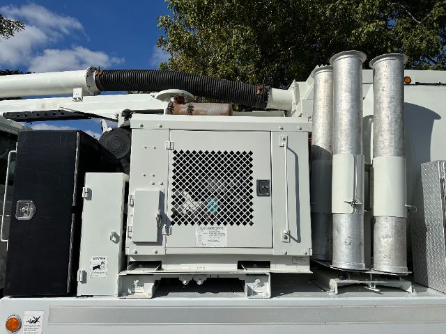Industrial generator mounted on a truck bed with exhaust stacks and a vented panel.
