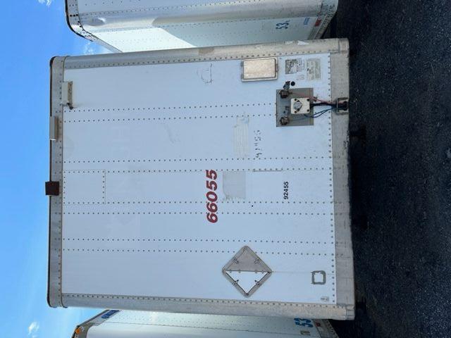Rear view of a white dry van trailer with red serial number 66055, side door handle, bumper, and coupling area visible.
