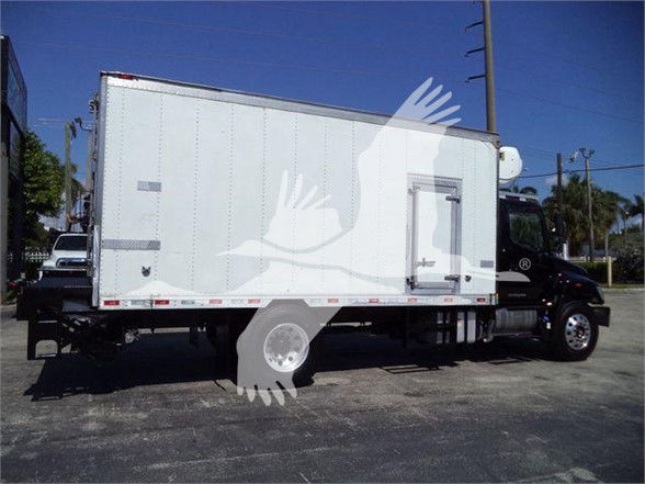 Truck with a white refrigerated box on a black cab, side view. Visible text includes VIN and stock number in listing, no other legible labels on the box.
