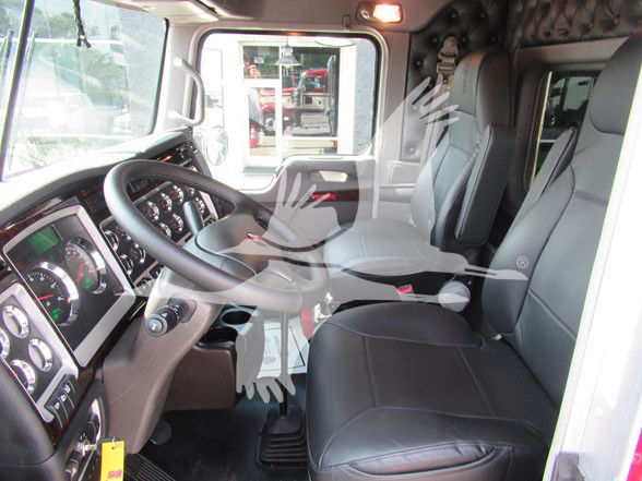 Kenworth W900L truck interior showing steering wheel dashboard and two front seats.