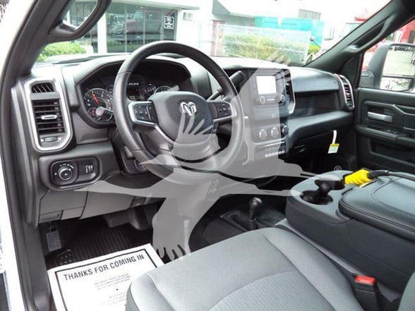 Interior of a 2024 Ram 4500 SLT pickup truck showing steering wheel, dashboard, center console, and front seats.