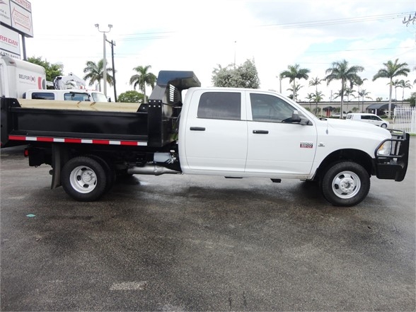 2012 Ram 3500 SLT white crew cab dump truck with black dump bed, side view showing dual rear wheels and side step.