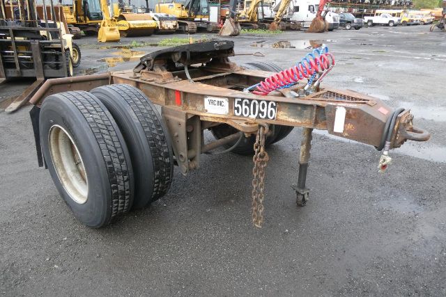 Trailer chassis with dual rear tires, spare wheel, rusted frame, chain, and coiled air line. License plate 56096 displayed on side; hitch and landing gear visible.