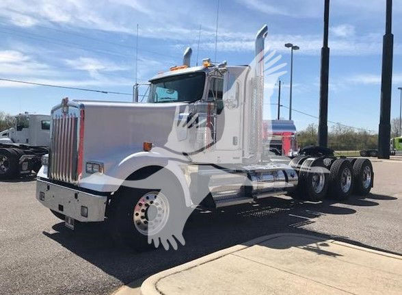 Kenworth W900L conventional daycab tractor with a white paint job, chrome exhaust stacks, and dual rear axles. Front grille and bumper visible.