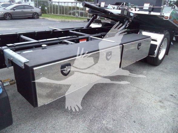 Flatbed truck side toolbox and chassis showing storage boxes and undercarriage with Freightliner M2 style frame.