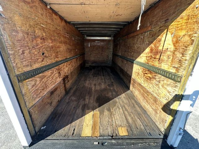 Box truck interior showing wooden cargo area with side rails and rear doors open, empty floor and plywood walls.