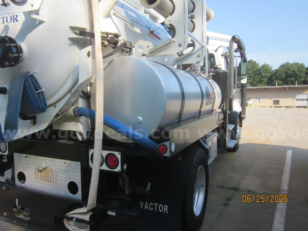 Freightliner Vactor Truck rear-side view showing cylindrical stainless tank, hoses, and rear lights.