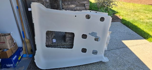 Volvo 760 sleeper truck part panel with cutouts leaning against a wall in a driveway.
