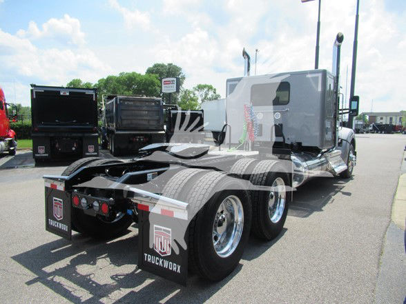 Kenworth W990 sleeper cab tractor rear view showing dual rear axles and mud flaps with TruckWorx branding.