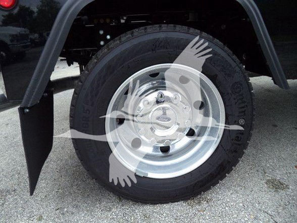 Wheel of a 2024 Ford F450 tow truck showing a steel rim and tire with mud flap; no legible text visible.
