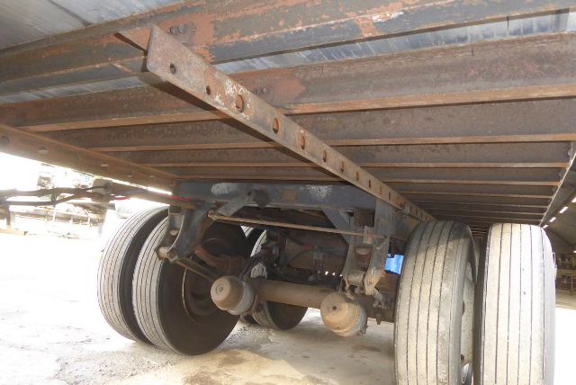 Great Dane trailer underside showing dual rear axles and leaf spring suspension with visible tires and frame members.