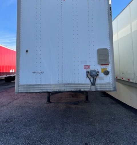 Van trailer rear view showing utility 4000DX trailer with wheel legs and rear access plug panel.