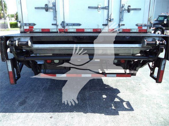 Refrigerated truck rear showing hydraulic lift and rollers, with reflective tape and double rear doors.