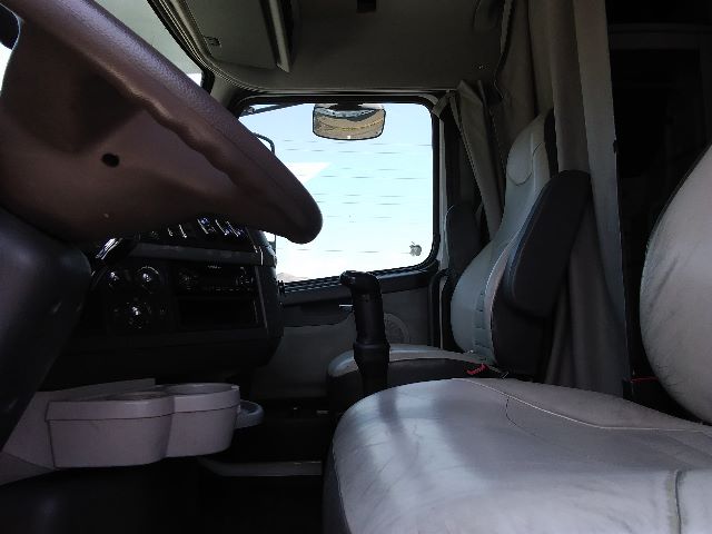 Volvo 670 interior view showing steering wheel, dashboard, driver seat, and gear lever in cab.