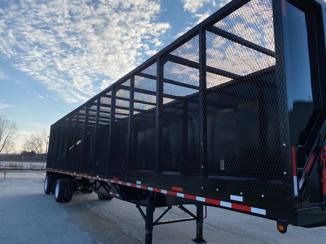 2008 Transcraft 48 ft crush car carrier trailer with mesh side panels and dual rear wheels on a trailer hoe with undercarriage support.