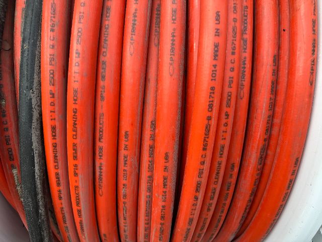 Orange and red hydraulic hoses coiled together in a bundle.