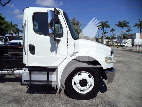 Freightliner Business Class M2 106 cab displaying side profile with front wheel, white paint, and diamond plate step.