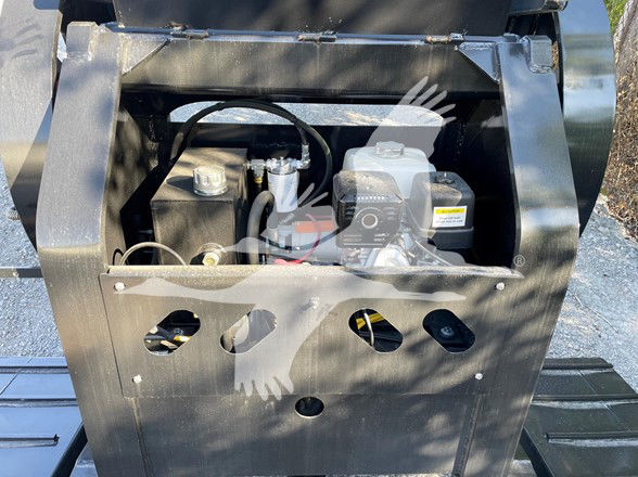 Mini deck trailer engine bay showing small gas engine with reservoir and cables.