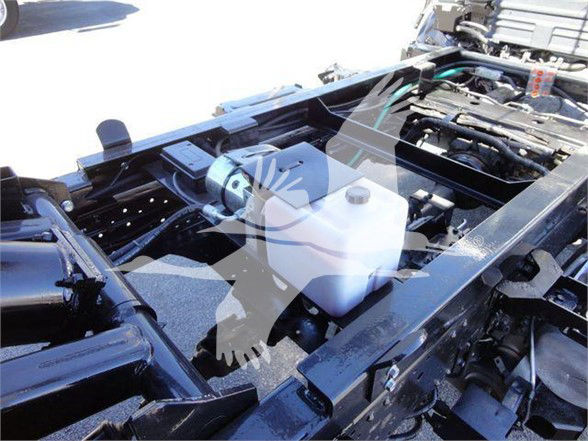 Isuzu NRR truck chassis with engine bay visible; coolant reservoir and various hoses; white translucent poll mask watermark over image.