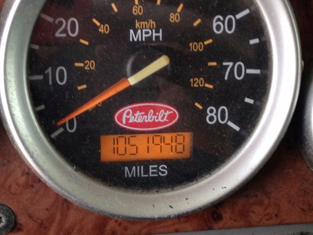 Peterbilt gauge cluster with speedometer showing up to 80 mph, and an orange digital odometer reading 1051948 miles. Peterbilt logo centered.