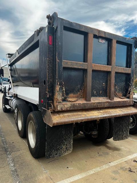 Dump truck trailer showing a side view with a large Cat T660S container and multiple wheels stacked along the chassis.