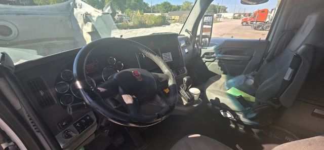 Kenworth T680 truck interior showing steering wheel, dashboard, and driver seat.