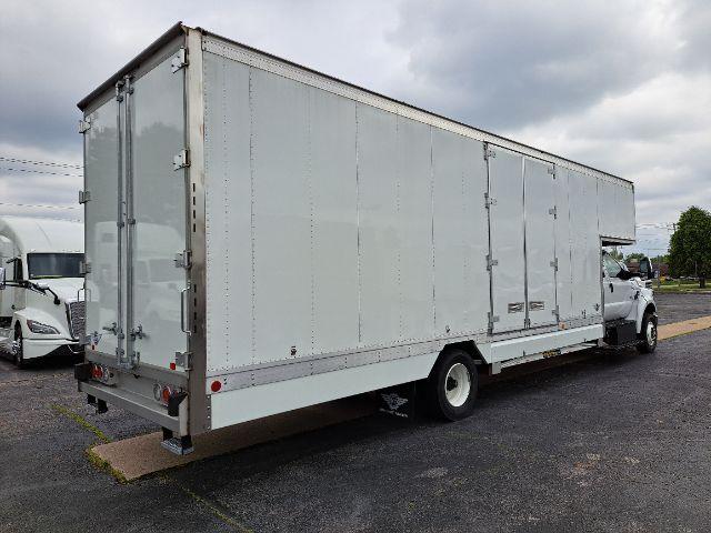 Box truck with a large enclosed cargo body and cab at the front, side door panels, rear doors, and a single rear axle.