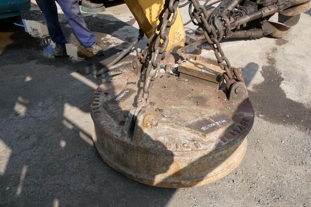 Hanging heavy-duty circular LGP clamshell/rotary iron disk attached by chains for a recycling truck, with text markings on the rim and a worker in the background.