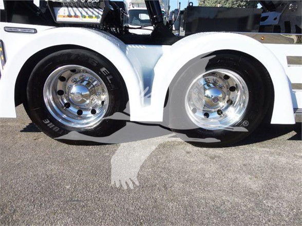 Two front wheels of a Freightliner Business Class M2 106 truck showing chrome rims and black tires, with part of the white body and chassis visible.