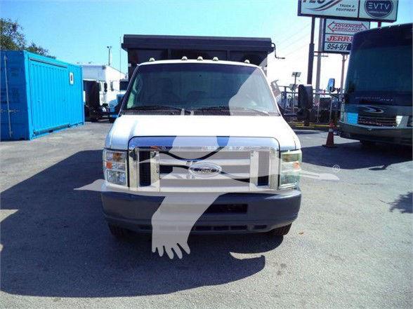 Front view of a white 2011 Ford E450 dump truck with black front bumper and grille, large windshield, and a dump bed visible in the background.