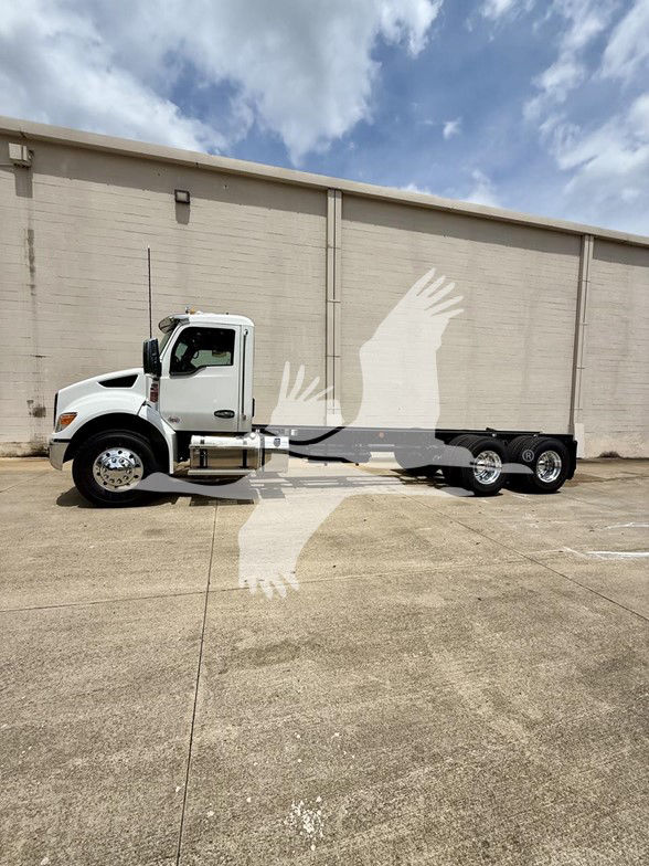 Kenworth T480 cab and chassis, white truck with long wheelbase, no cargo bed visible, side view of cab and dual rear axles on a concrete lot.