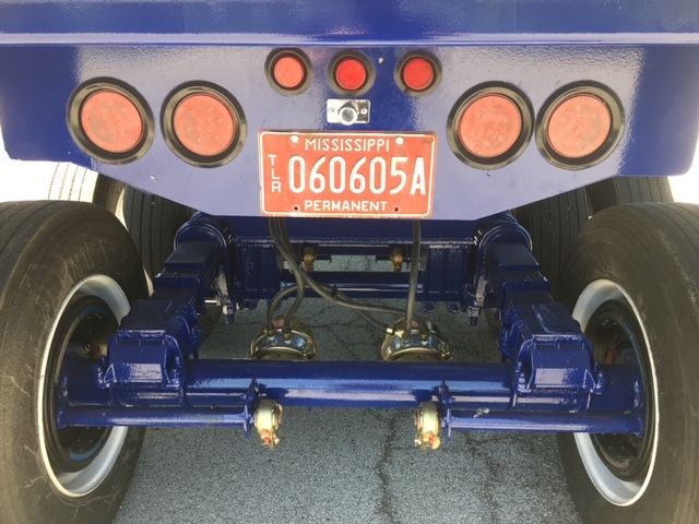 Rear view of a blue utility 40 ft square dump trailer showing dual axles, suspension, and Mississippi license plate 060605A.