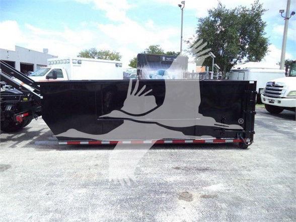 Freightliner Business Class M2 106 refuse truck side panel with black paint and white graphic, multiple trucks in background.