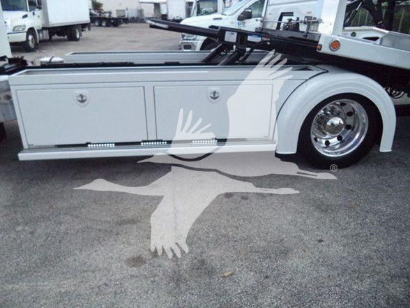 Side view of a 2022 Peterbilt 337 tow truck with storage compartments and chrome wheel. Visible text includes generic truck details but no legible model or serial text readable on the image.