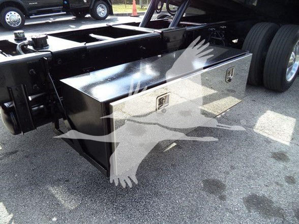 Stock truck chassis with a large black aluminum tool/storage box mounted behind the cab; shows two latching compartments on the front face of the box; Hino 258ALP tow truck context in listing.
