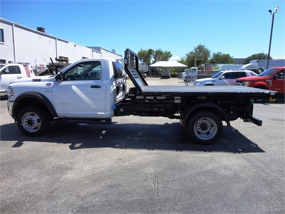 Ram 5500 HD hooklift truck profile showing flatbed with crane/hoist setup and white cab
