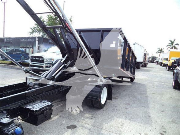 Isuzu NRR refuse truck body in a used condition with hydraulic lift and dumpster hopper visible.