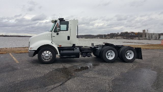 2007 International 8600 cab and chassis truck in a parking lot, side view showing white cab, dual rear axles, and empty chassis.