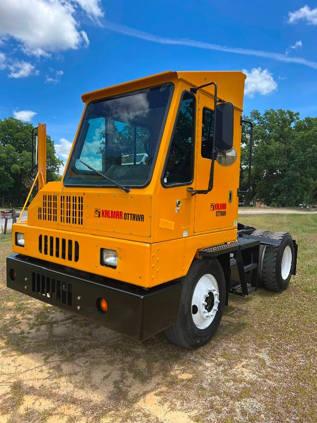 Kalmar Ottawa YT30 yard truck in orange with front grille, cab, and large side mirror shown in outdoor lot.