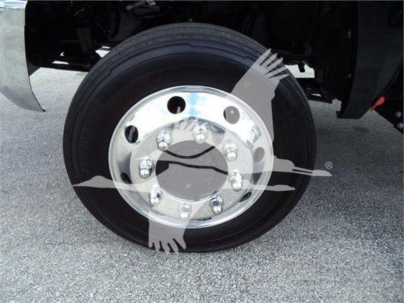 Wheel close-up on a 2023 International CV tow truck showing a polished silver steel rim with multiple lug nuts and black tire.
