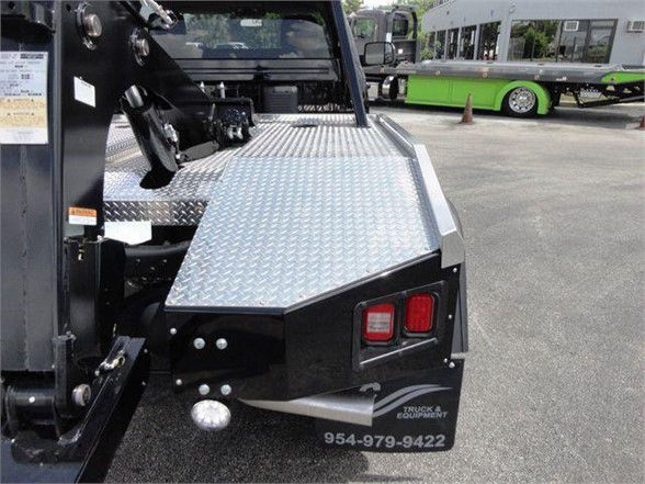 Ram 4500 HD SLT tow truck rear view with diamond plate platform and taillights visible.