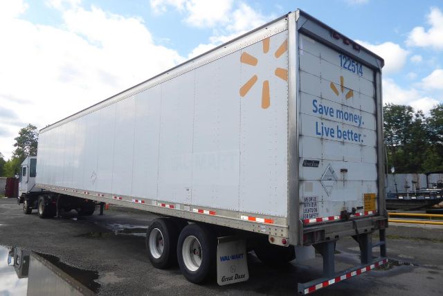 Great Dane trailer in a truck yard showing a white cargo trailer with Walmart sunburst logo and blue slogan on the rear doors.
