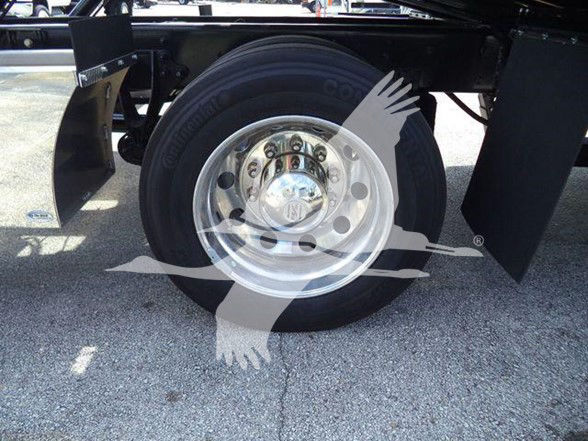 Wheel and tire assembly on a truck showing a shiny aluminum rim and mounted hub with surrounding tire.