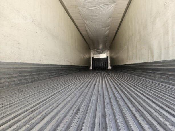 Interior of a Utility 3000R trailer trailer bed with ribbed floor and a rear doorway.