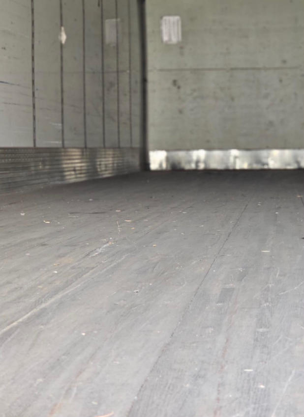 Trailer interior with wooden floor and side walls; no visible equipment labels or fluid reservoirs.